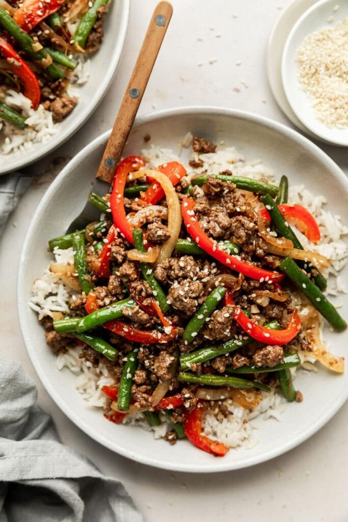 Savory, crispy bits of ground beef are tossed with blistered green beans, sweet red bell peppers, and sliced onions in a sticky, sweet-and-savory soy ginger sauce.