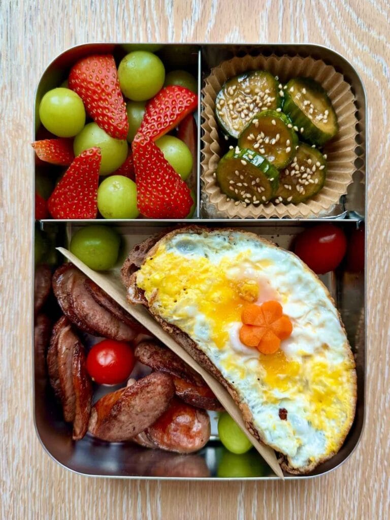 Stainless Steel Bento with Fried Egg Toast, Sausages, and Sesame Cucumbers